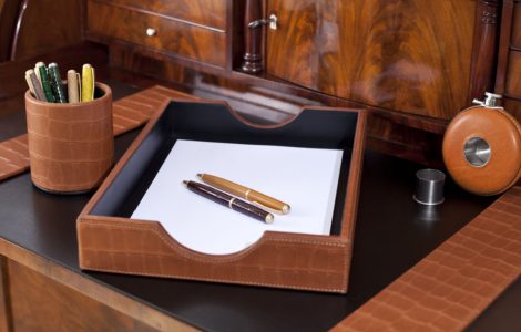 Un bureau en bois luxueux avec des stylos et un tiroir dessus