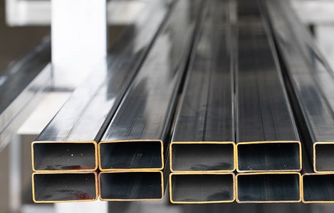 Des tubes rectangles en acier empilées dans un atelier