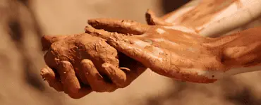 Mains d'une femme tenant une pièce d'argile humide