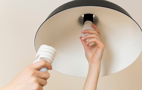 Femme remplaçant l'ampoule à la maison