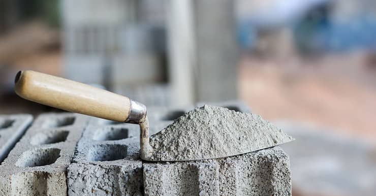 Du ciment sur une truelle posée sur des blocs de béton