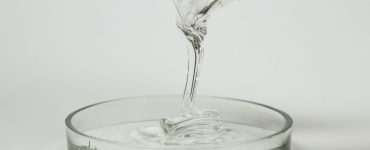Un liquide transparent qui se déverse dans un récipient en verre