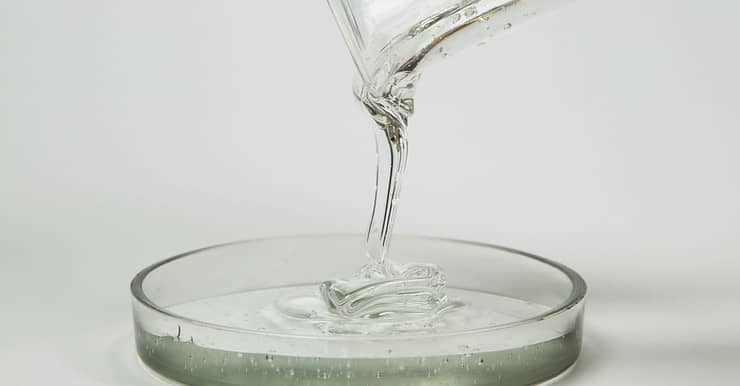 Un liquide transparent qui se déverse dans un récipient en verre