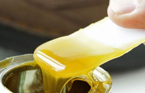 Focus sur une main en train de prendre de la colle dans une boite