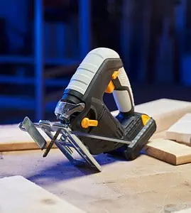 Une scie sauteuse et un mètre ruban posés sur une table dans un atelier