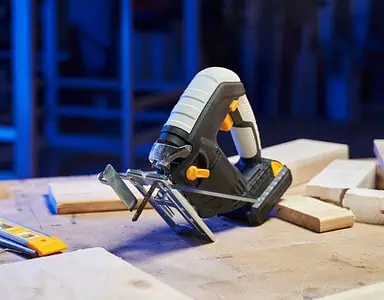 Une scie sauteuse et un mètre ruban posés sur une table dans un atelier