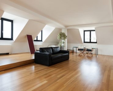 Un grand salon sous pente avec un sol en parquet