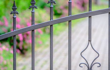 Vue sur une clôture en fer forgé peinte en gris
