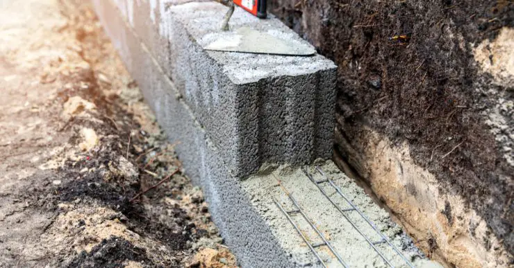 Travaux de construction des fondations d'un mur à partir de blocs d'argile étendus