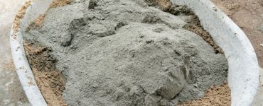 Préparation d'un mortier avec du ciment et du sable dans un grand bac