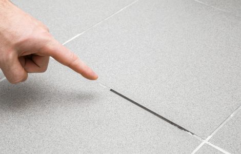Zoom sur la main d'un homme montrant un joint de carrelage évidé