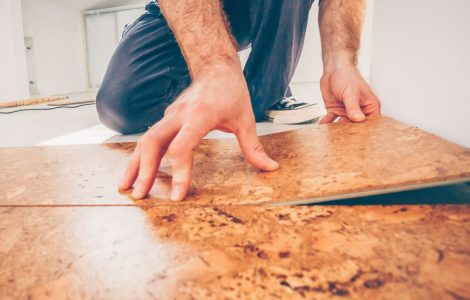 Un homme en train de poser un revetêment de sol en liège