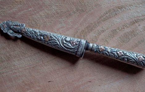 Un couteau de nickel argenté avec des motifs posé sur une surface en bois