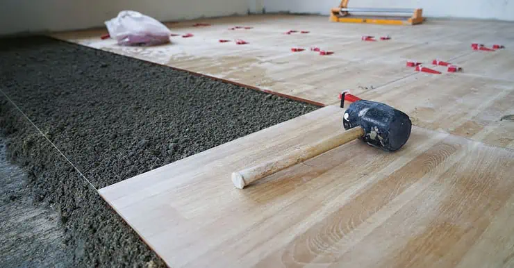 Un maillet posé sur le carreau lors des travaux de pose de carrelage de sol