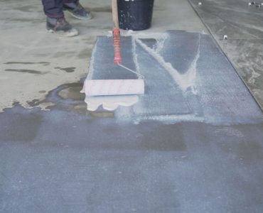 Un homme prépare le sol pour la pose du carrelage