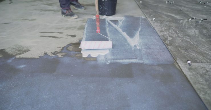 Un homme prépare le sol pour la pose du carrelage