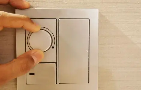 Zoom sur la main d’une personne en train de régler le variateur de lumière