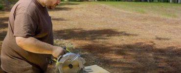 Un homme sciant une plaque de bois avec une scie circulaire