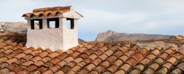 Vue sur une toiture en terre cuite avec une cheminée