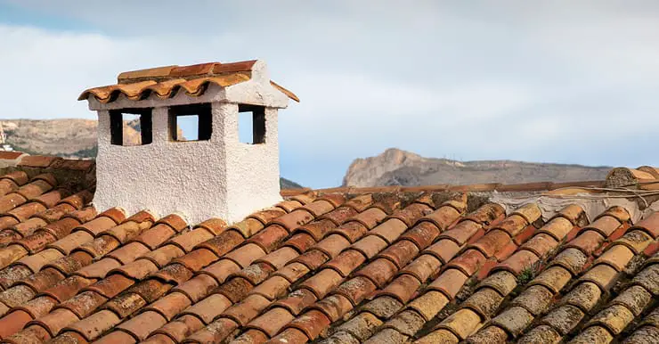 Vue sur une toiture en terre cuite avec une cheminée