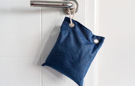 Petit sac bleu accroché à une poignée de porte par une corde