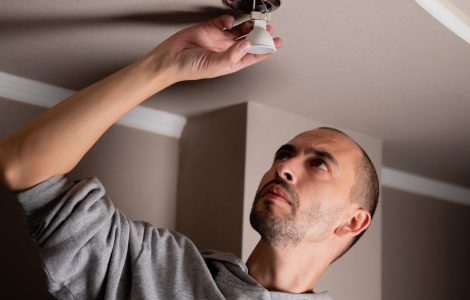 Un homme retirant un spot encastré au plafond