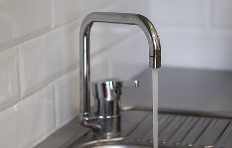 Un robinet d’évier ouvert qui laisse couler l’eau abondamment