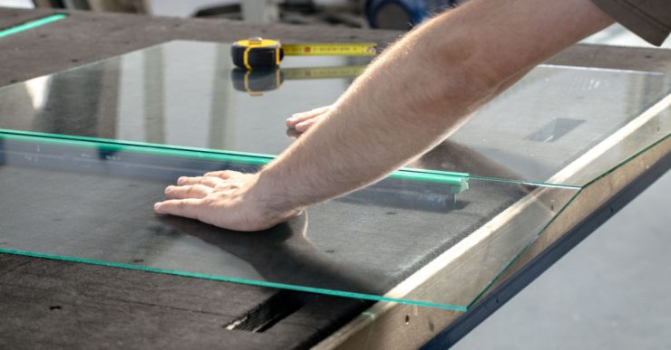 Un homme coupe du verre dans son atelier