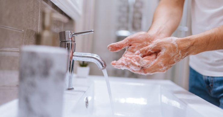 Gros plan sur un homme se lavant les mains dans le lavabo