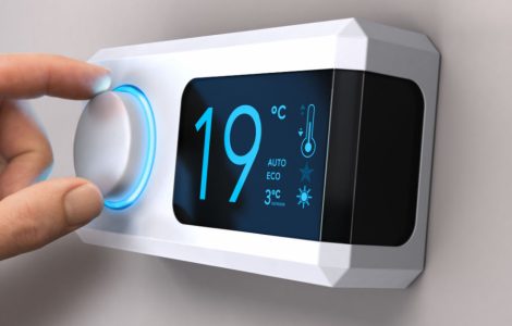 Main tournant un bouton de thermostat pour régler la température de la maison