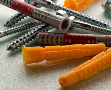 Plusieurs vis et chevilles posées sur une table