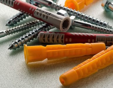 Plusieurs vis et chevilles posées sur une table