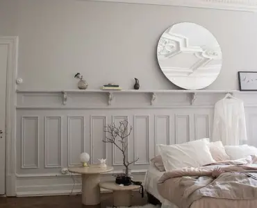 Une chambre aux murs blancs et des moulures bien dessinées