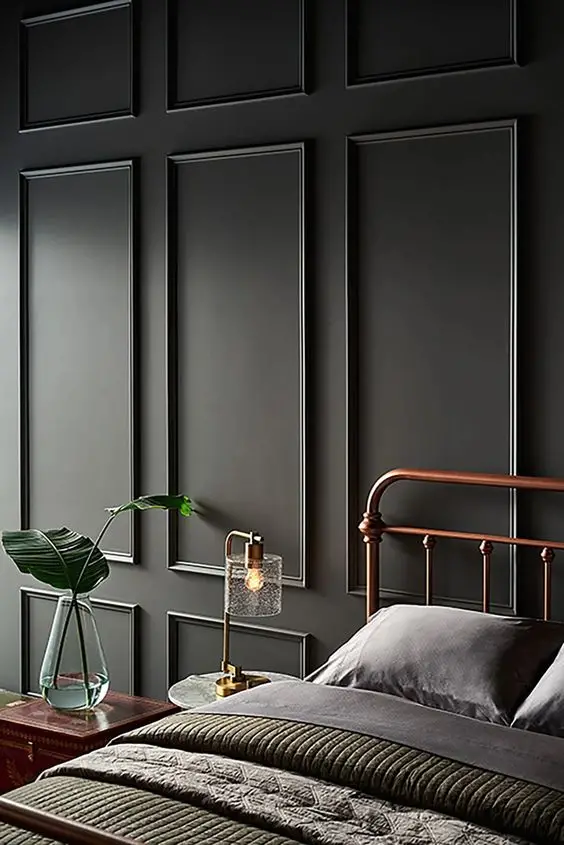 Un pan de mur gris/vert avec des encadrements décoratifs ton sur ton dans la chambre à coucher 