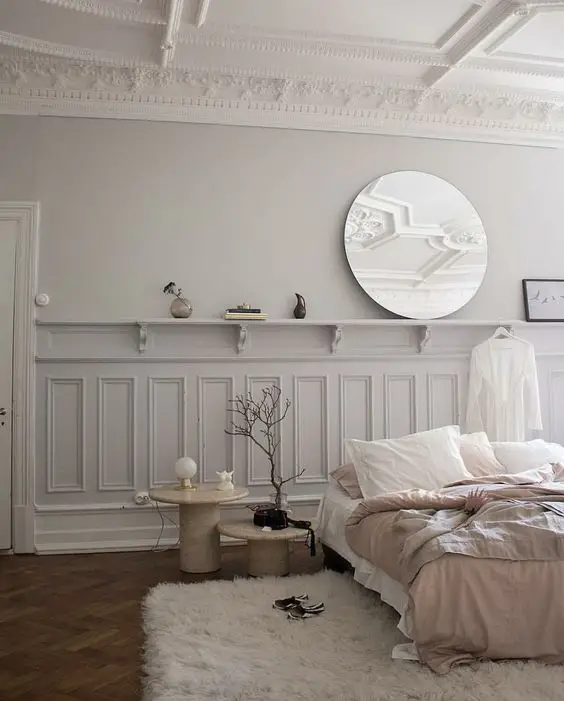 Une chambre aux murs blancs et des moulures bien dessinées