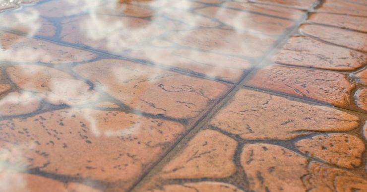 Flaque d'eau sur le sol en briques brunes à l'extérieur