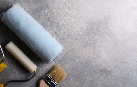 Outils de peinture, pinceau et rouleaux, posés sur le sol