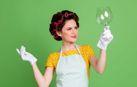 Une femme en gants blancs tenant un verre vide