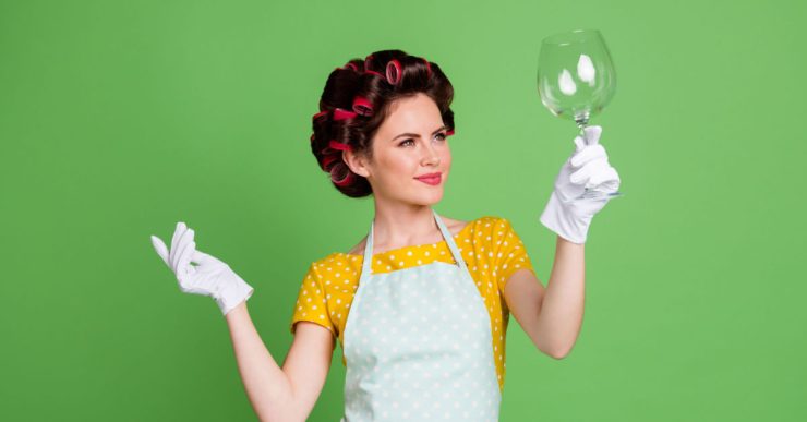 Une femme en gants blancs tenant un verre vide