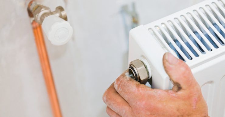 Zoom sur la main d'un homme réparant le radiateur de la maison