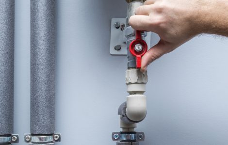 Gros plan sur une main fermant le robinet d'arrêt