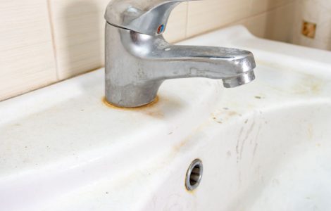 Un vieux lavabo sale avec des taches de rouille et de calcaire