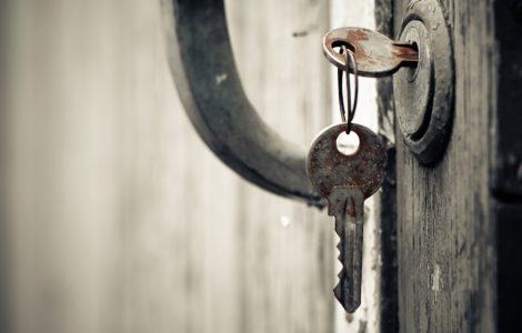 Une clef rouillée insérée dans la serrure d'une vieille porte en bois