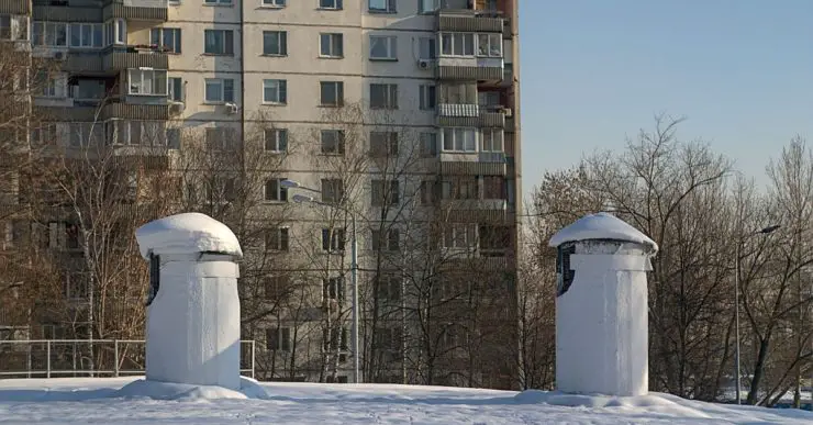 Des puits de ventilation installés à l'extérieur avec, en fond, un immeuble