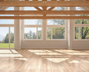 Une pièce vide avec parquet et armatures de toit en bois, fenêtre panoramique