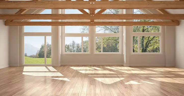 Une pièce vide avec parquet et armatures de toit en bois, fenêtre panoramique