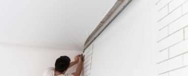 Un ouvrier en train d'étendre le plafond suspendu d'une pièce