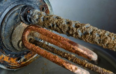 Zoom sur une pièce du chauffe-eau électrique pleine de tartre