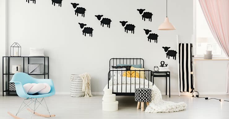 Une chambre d'enfant avec des autocollants de mouton noir au mur