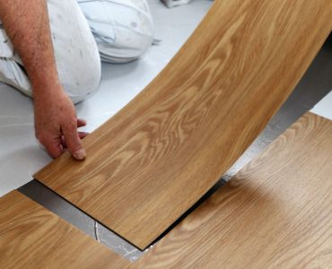 Un homme en train de poser un sol en PVC